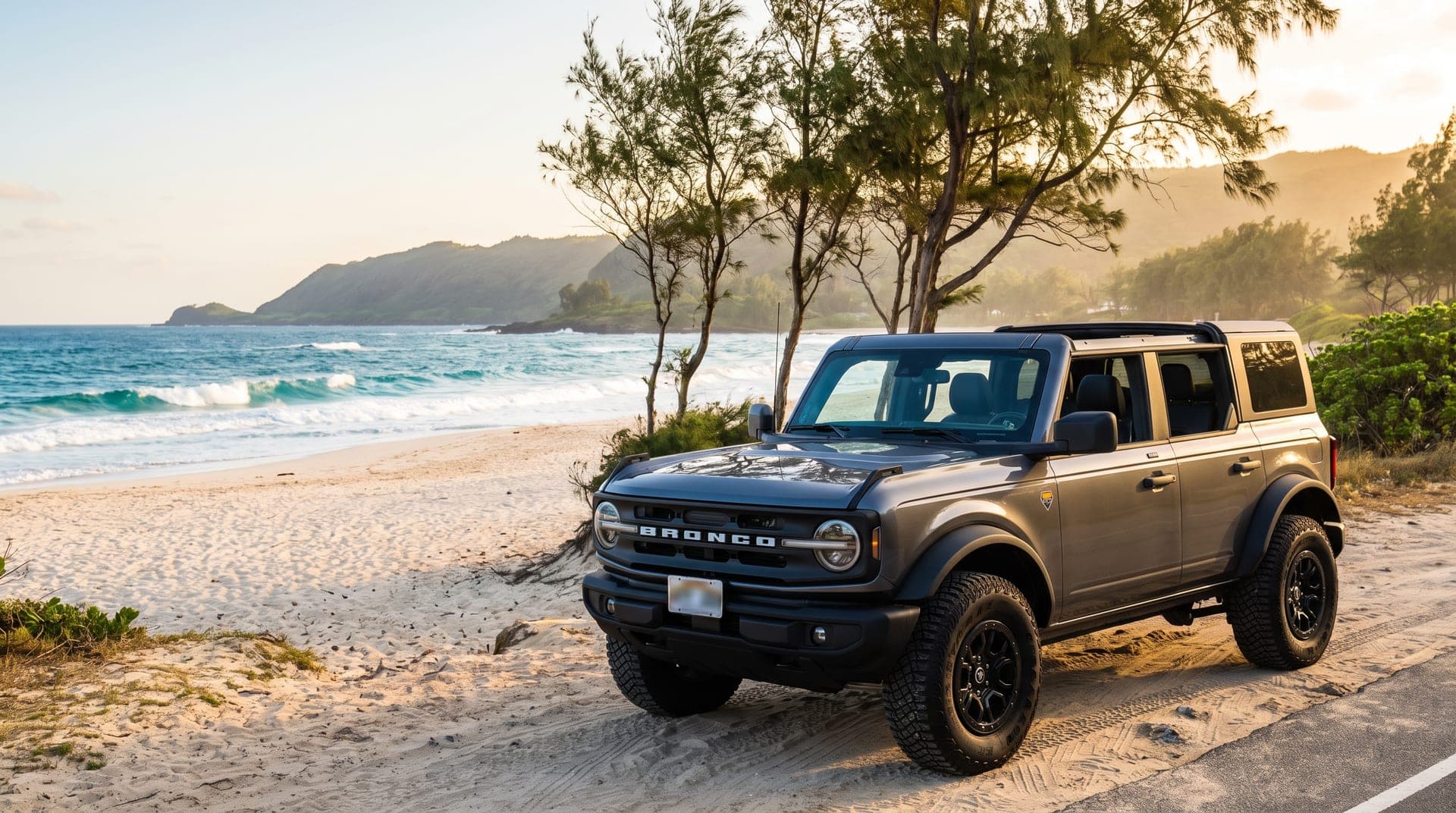 Ford Bronco with its soft top folded back beside a North Shore beach road, Oahu, Hawaii